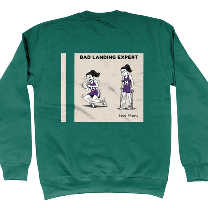 Green Netball Jumper with Funny Bad Landing Expert Cartoon Print